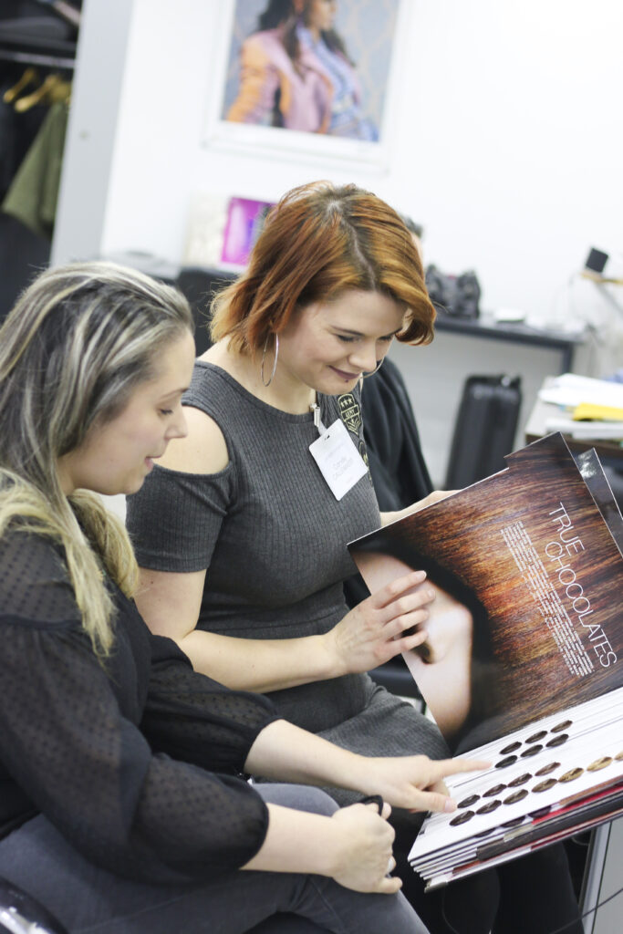 Coiffeuse qui réalise un diagnostic coiffure avec sa cliente